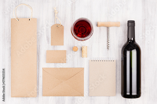 Corporate identity template for wine industry with bottle red wine and wineglass on soft white wood background. Mock up for branding, advertising, design, business presentations and portfolios.