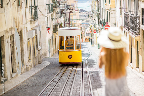 mloda-kobieta-turysta-fotografuje-slawnego-retro-zoltego-tramwaju-na-ulicie-w-lisbon-miescie-portugalia-kobieta-jest-nieostra