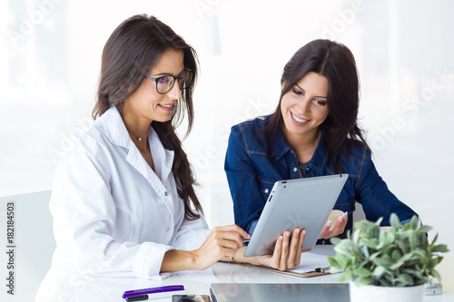 Doctor and her patient choosing mammary prosthesis in the office.