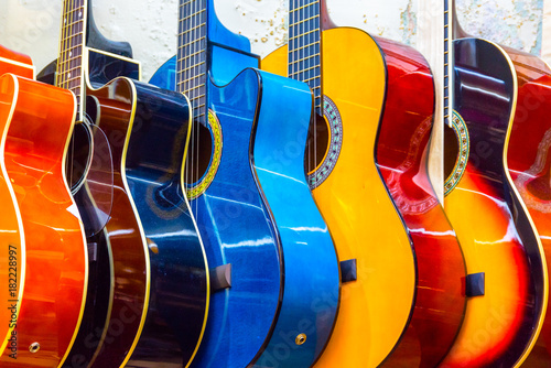 colorful-wooden-guitars-hanging-on-wall-of-store-showroom