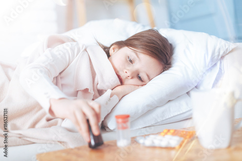 cover your throat sick child keeping head on big pillow while lying