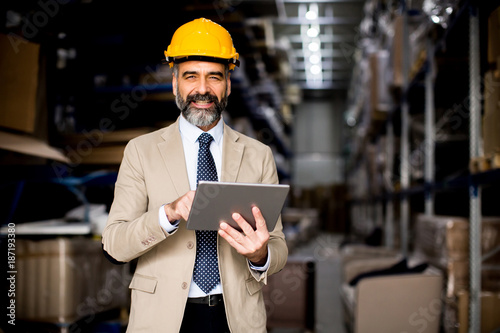Middle-aged businessman with digital tablet in factory