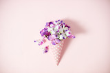 Top view to purple hydrangea in a pink cone with hearts on pink background