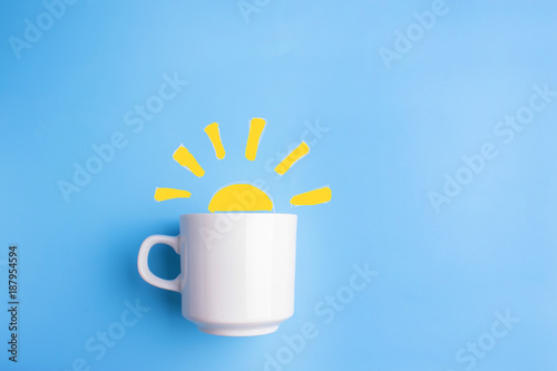 sun and white cup on blue background
