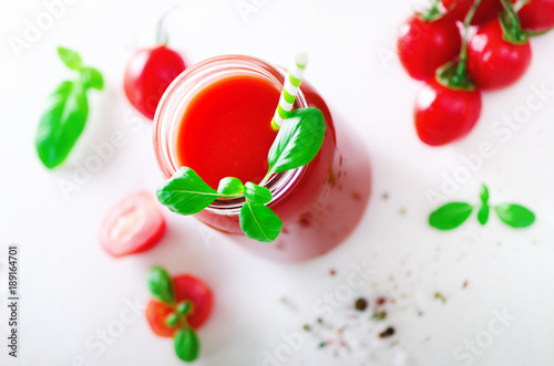 organischer-frischer-tomatensaft-in-einem-glasgefas-in-einem-basilikum-in-einer-kirsche-in-einem-salz-in-einem-pfeffer-und-in-einem-stroh-auf-hellem-hintergrund-sauberes-essen-und-diatkonzept-kopieren-sie-platz