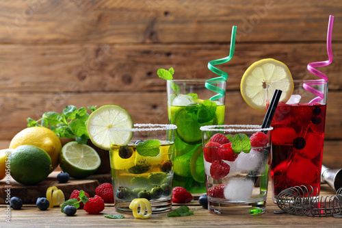 fruchtcocktailhintergrund-vier-glaser-mit-beeren-und-zitrusfruchten-wasser