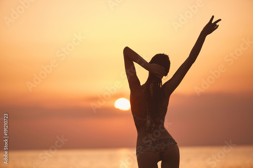 silueta-de-una-hermosa-nina-sexual-contra-el-mar-y-la-puesta-de-sol-mujer-feliz-disfrutando-de-las-vacaciones-de-verano