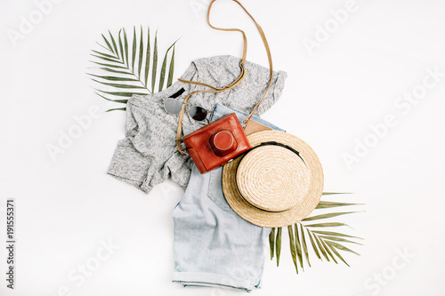 Woman fashion travel flatlay. Retro camera, straw, shorts, sunglasses and tropical palm leaf. Top view, flat lay.
