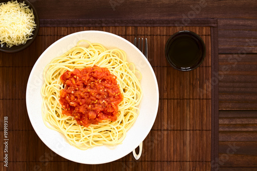 traditionelle-italienische-spaghettis-alla-marinara-spaghettis-mit-tomatensauce-in-der-schussel-mit-rotwein-und-geriebenem-kase-auf-der-seite-fotografiert-oben-auf-dunklem-holz-mit-naturlichem-licht