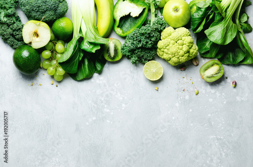 organisches-grunes-gemuse-und-fruchte-auf-grauem-hintergrund-textfreiraum-flache-lage-draufsicht-gruner-apfel-kopfsalat-zucchini-gurke-avocado-kohl-kalk-kiwi-trauben-banane-brokkoli