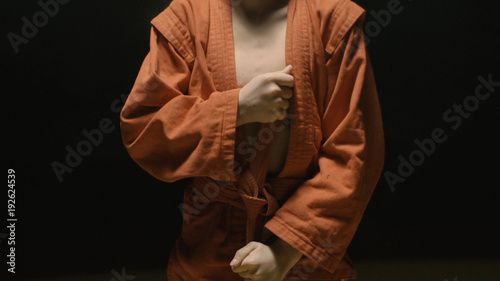 Sportsman boy in a red kimono for judo. Boy puts on a red kimono in preparation for training or sparring © Media Whale