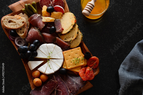 kaseplatte-auf-einem-brett-ein-anderer-kase-mit-fleisch-snack-jamon-prosciutto-camembert-parmesan-oliven-basiron-pesto-mit-basilikum-tapas-bar-draufsicht