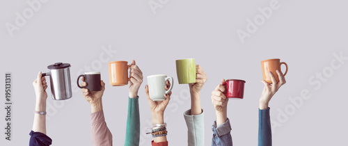 Many different arms raised up holding coffee cup