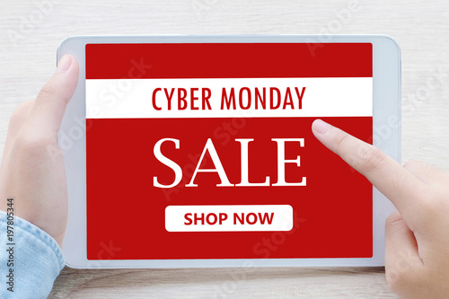 Hand using tablet with cyber monday sale on screen device over blur background with copy space, business technology and lifestyle concept