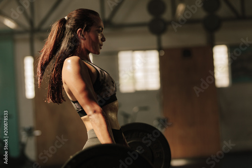 Physically fit woman lifting heavy weights © Jacob Lund 