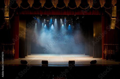An empty stage of the theater, lit by spotlights and smoke before the performance