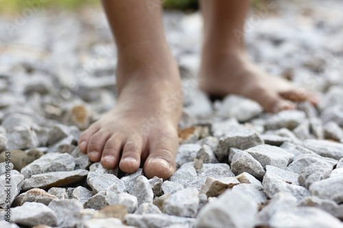 Closeup Of A Girl Bare Feet Walking On Stones Rock 