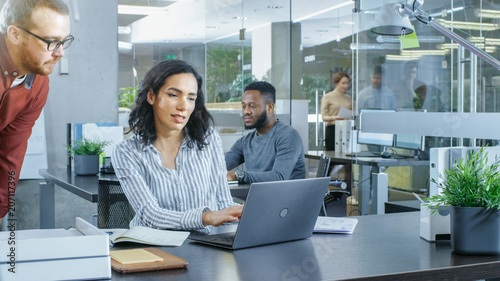 In the Busy Corporate Office Male and Female Have Work Related Discussion, Using Personal Computer. In the Background Creative Young People Working.