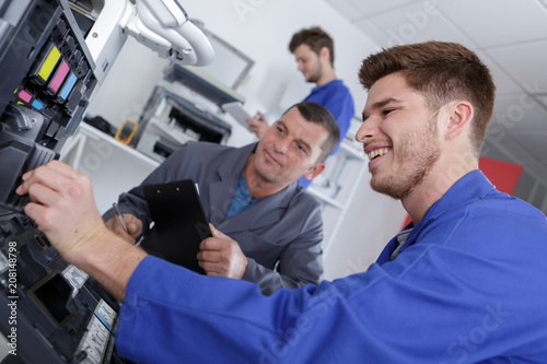 apprentice repairing printer with teacher monitoring © auremar