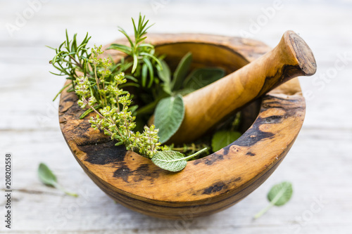 Fresh and aromatic herbs in a wooden mortar. © iMarzi