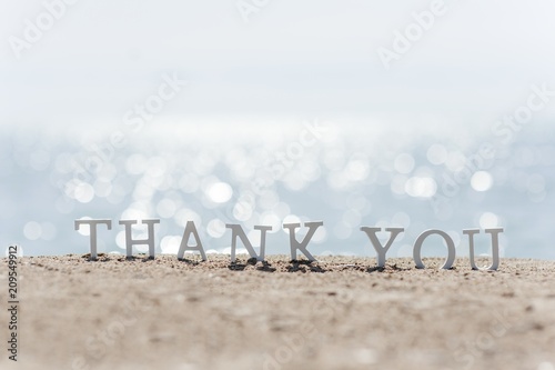 thank you word drawn on the beach sand © tanialerro