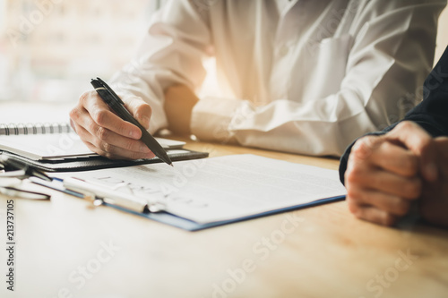 Businessman with pointing to paper about to sign a contract after successful agreement.