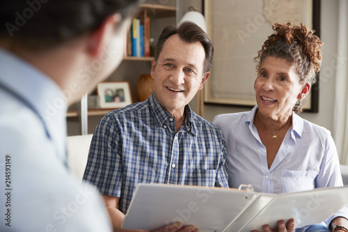 Senior Couple Meeting With Male Financial Advisor At Home