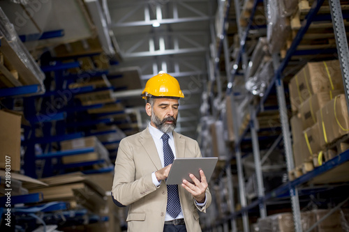 Middle-aged businessman with digital tablet in factory
