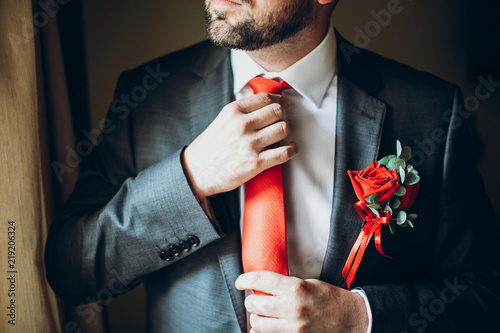 groom getting ready in morning, holding red tie. wedding day preparations © sonyachny