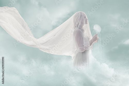 surreal portrait of bride in clouds hold jellyfish © Coka