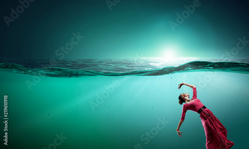 Woman dancer in clear blue water © Sergey Nivens