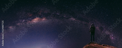 Night sky full of star and milky way, with traveller with backpack enjoying beautiful sky at night