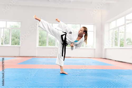 Sporty karate woman against big window standing in karate position. © serhiibobyk