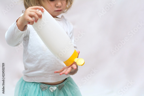 Beautiful Baby Holding A Bottle In The Hand With Shower Gel Beside