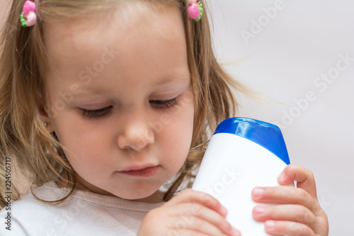 Beautiful Baby Holding A Bottle In The Hand With Shower Gel Beside