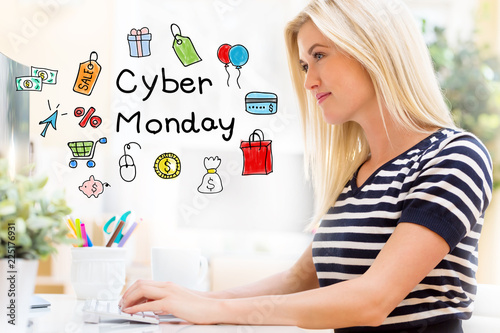 Cyber Monday with happy young woman sitting at her desk in front of the computer