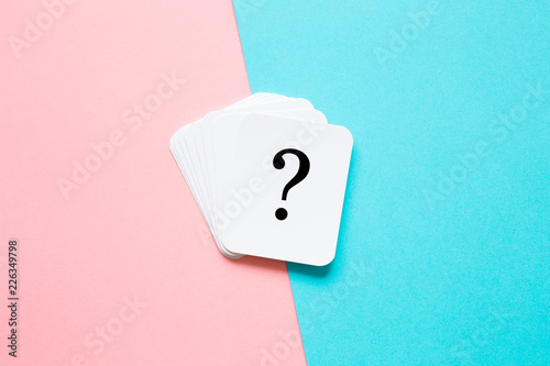 Card of question mark on pastel pink and turquoise blue background. Soft light color. Teenagers issues. Boys and girls or men and women problems and solutions concept. Couples relationships.