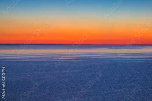  red sunset sky on the water surface of the estuary © Vadim Gnidash
