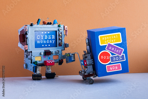 Cyber monday promotion poster. Funny robotic computer moving shopping cart with big blue box, sale stickers. Brown wall, blue floor background