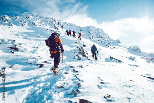 A group of climbers ascending a mountain in winter © kbarzycki