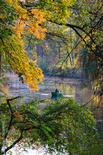 Romantic scene in the autumn park. The couple in the boat. © Natalia
