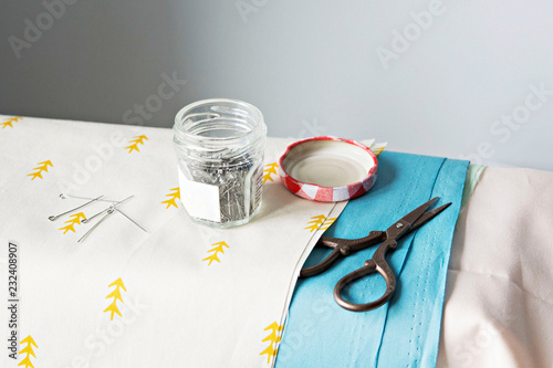 Metal pins, scissors, glass jar and cotton fabrics © Maryana Volkova