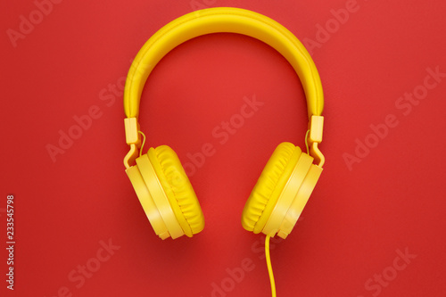 Yellow headphones on red background. Music concept. © Screaghin