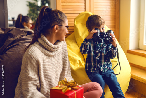 Mother And Son At Living Room Holding Christmas Gift While Mother And Son At Living Room Holding Christmas Gift While Sitting In Bean