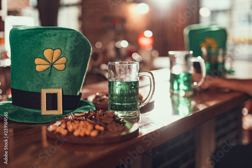 Leprechaun hat, mug of green beer and snacks on bar counter