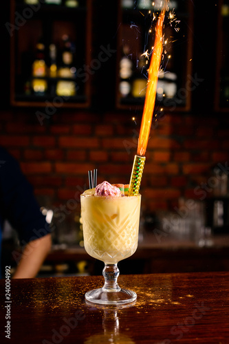 celebratory fire in a cocktail on the background of the bar, alcoholic birthday fireworks