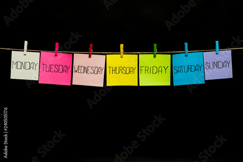 Copy space. Seven multicolored sheets with the names of the days of the week. Stickers attached to a rope clothespins.