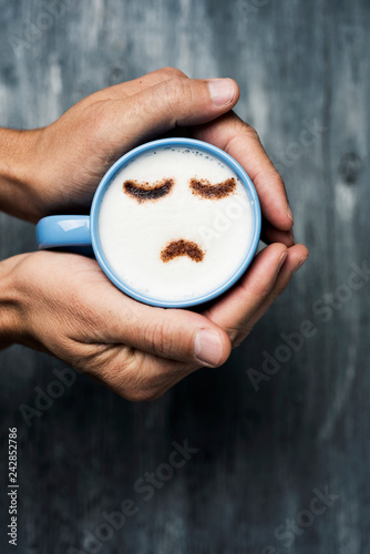 man with a cup of cappuccino with a sad face