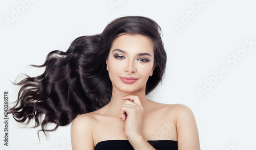 Cute woman with blowing curly hair on white. Beautiful female model face © millaf