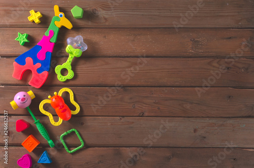 Top view or flat lay on colorful toys on dark wooden background with copy space. © mayanko